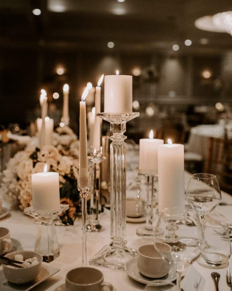 Pillar and dinner candles and table setting on wedding table close up
