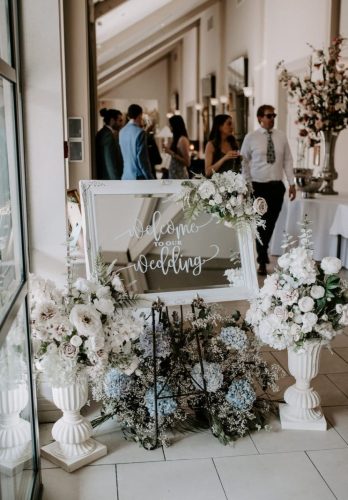 Wedding welcome sign surrounded by flowers close up by Rosewater Decor